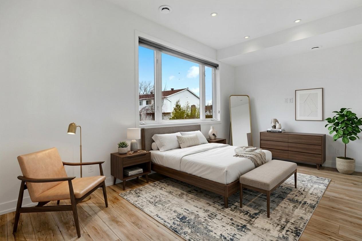The same bedroom staged with a double bed, armchair and chest of drawers