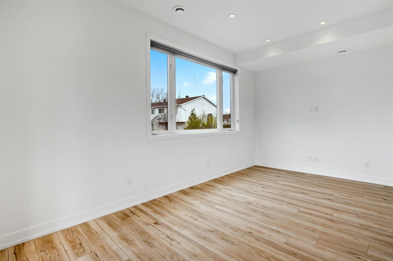 Empty double bedroom with a wide window, before staging